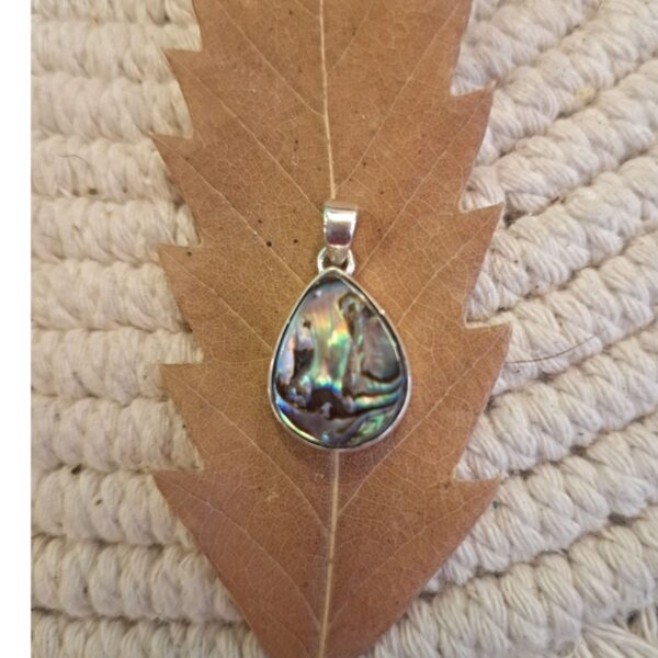 Close-up of iridescent abalone shell teardrop pendant in silver bezel